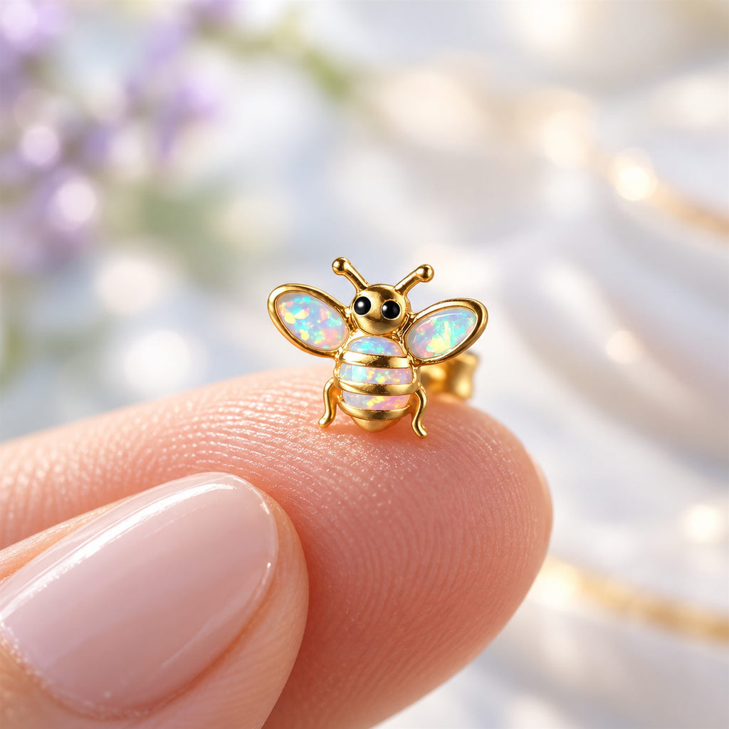 Boucles d'oreilles Abeille Mopaline, posée sur le bout du doigt pour montrer la petite taille