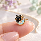 Boucles d'oreilles Chat Lune Mopaline, posée sur le bout du doigt pour montrer la petite taille