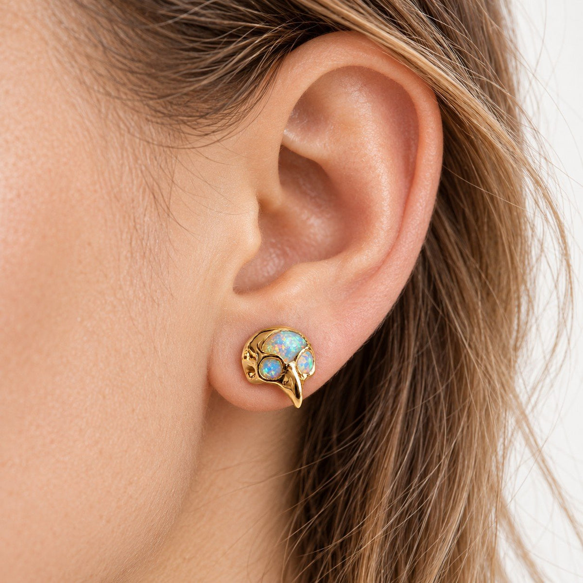 Boucle d'oreille Crâne d'Oiseau Opale portée sur le lobe