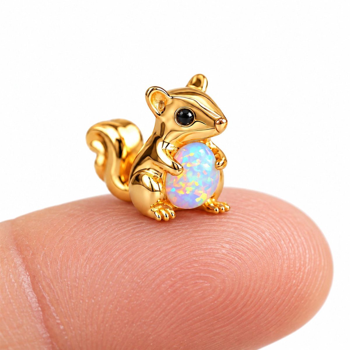 Boucle d'oreille Écureuil Opale posée sur le bout du doigt pour montrer sa petite taille