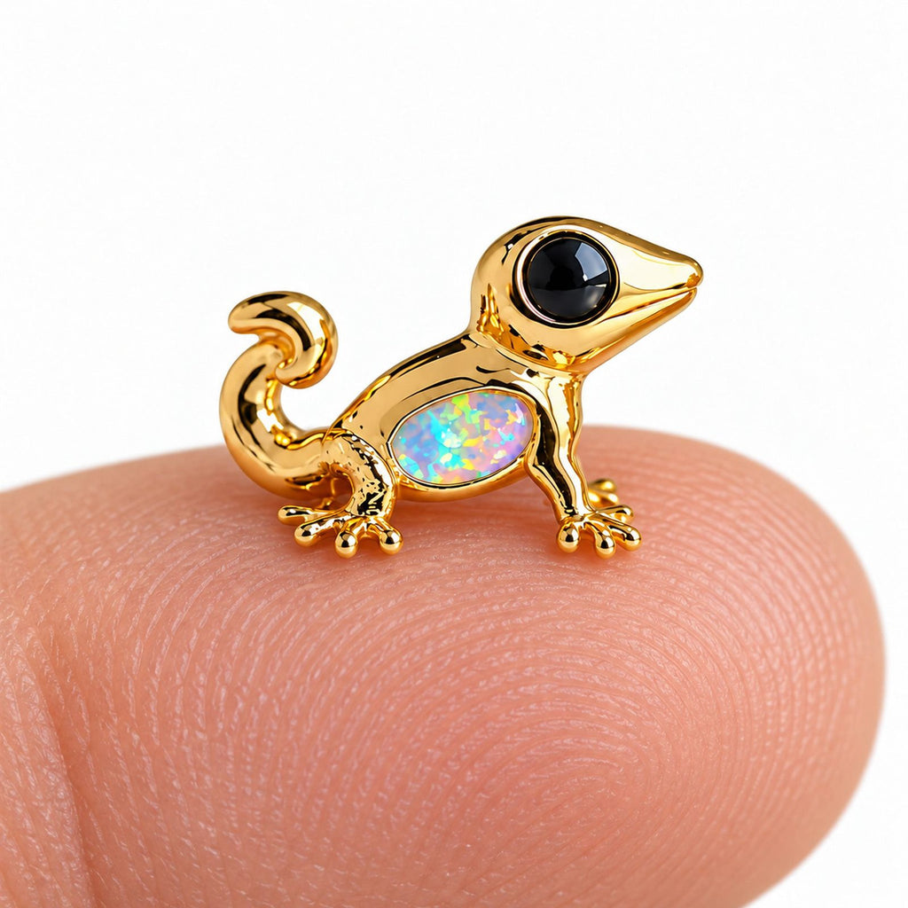 Boucle d'oreille Gecko Opale posée sur le bout du doigt pour montrer sa petite taille