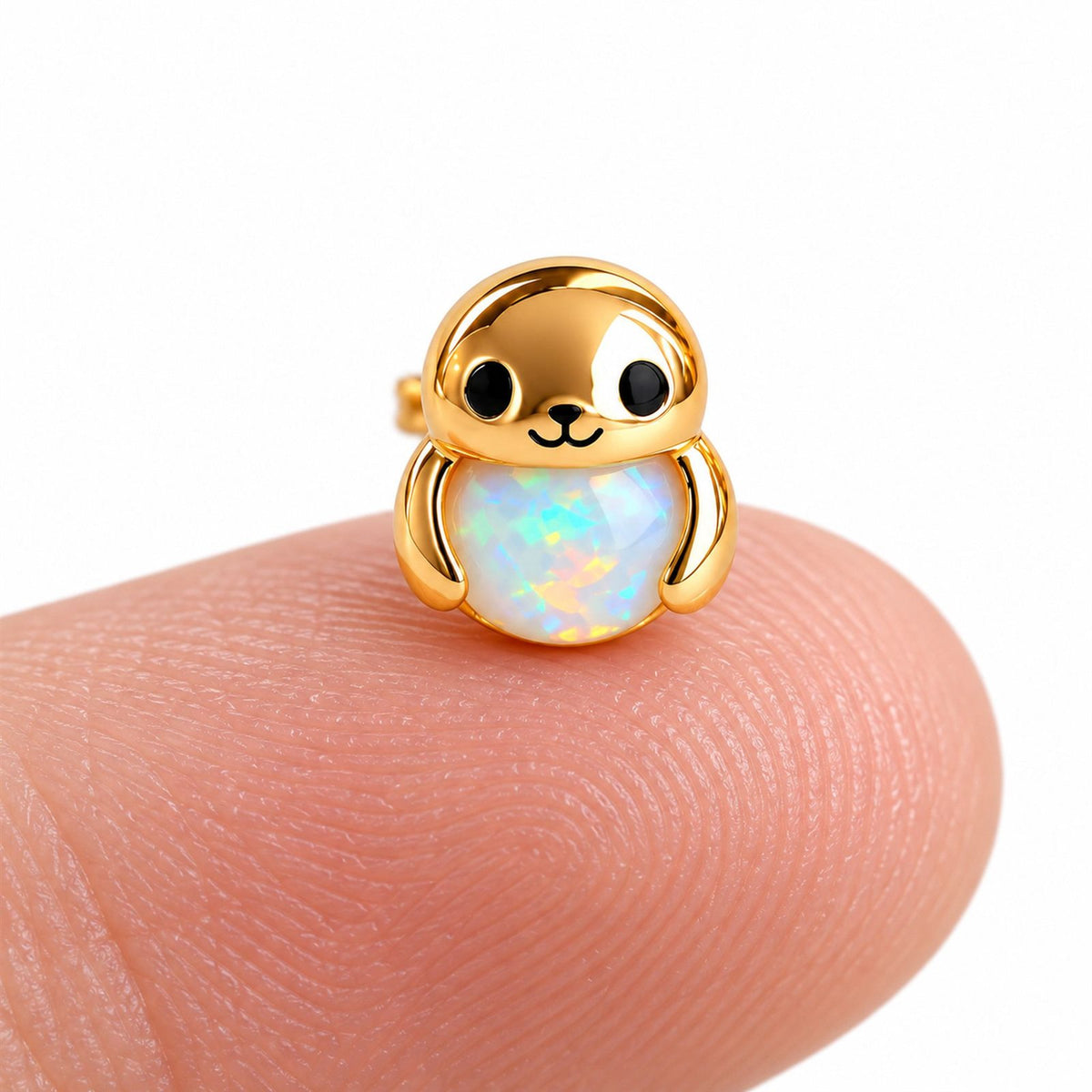 Boucle d'oreille Phoque Opale posée sur le bout du doigt pour montrer sa petite taille